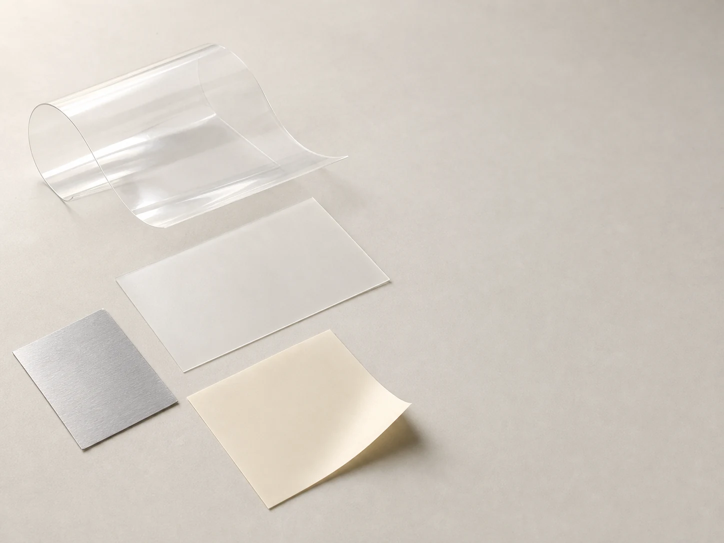 Illustrative unbranded clear, frosted, silver-gray and ivory flexible-material study.