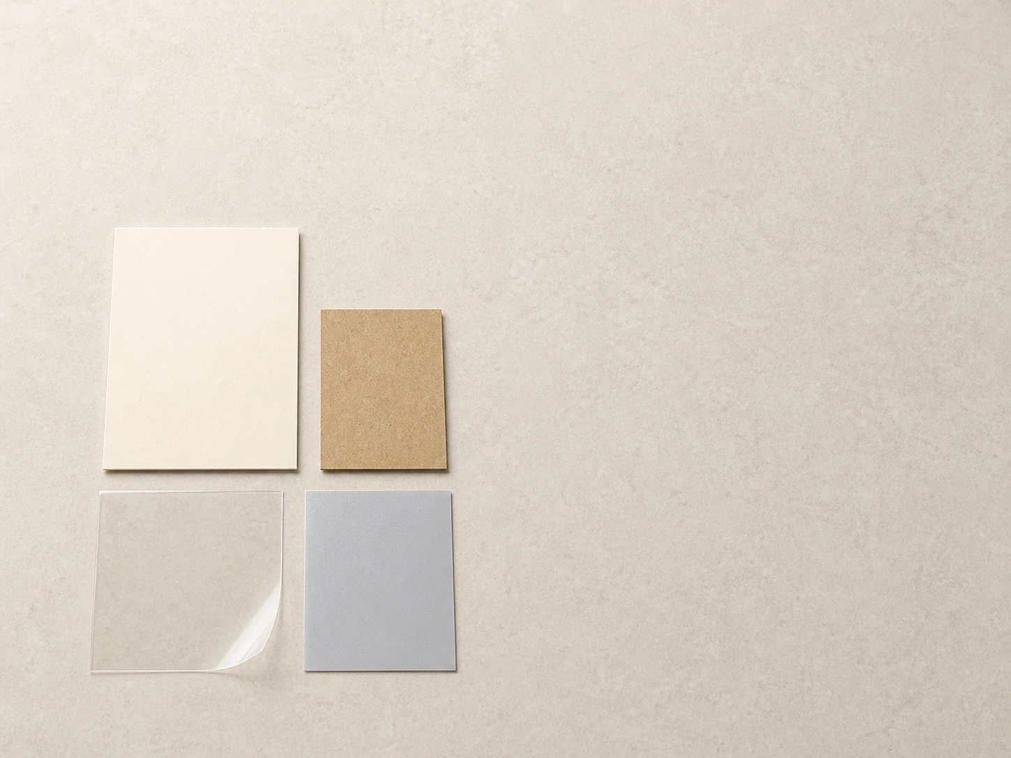 Illustrative unbranded ivory board, kraft board, clear film and silver-gray material study.